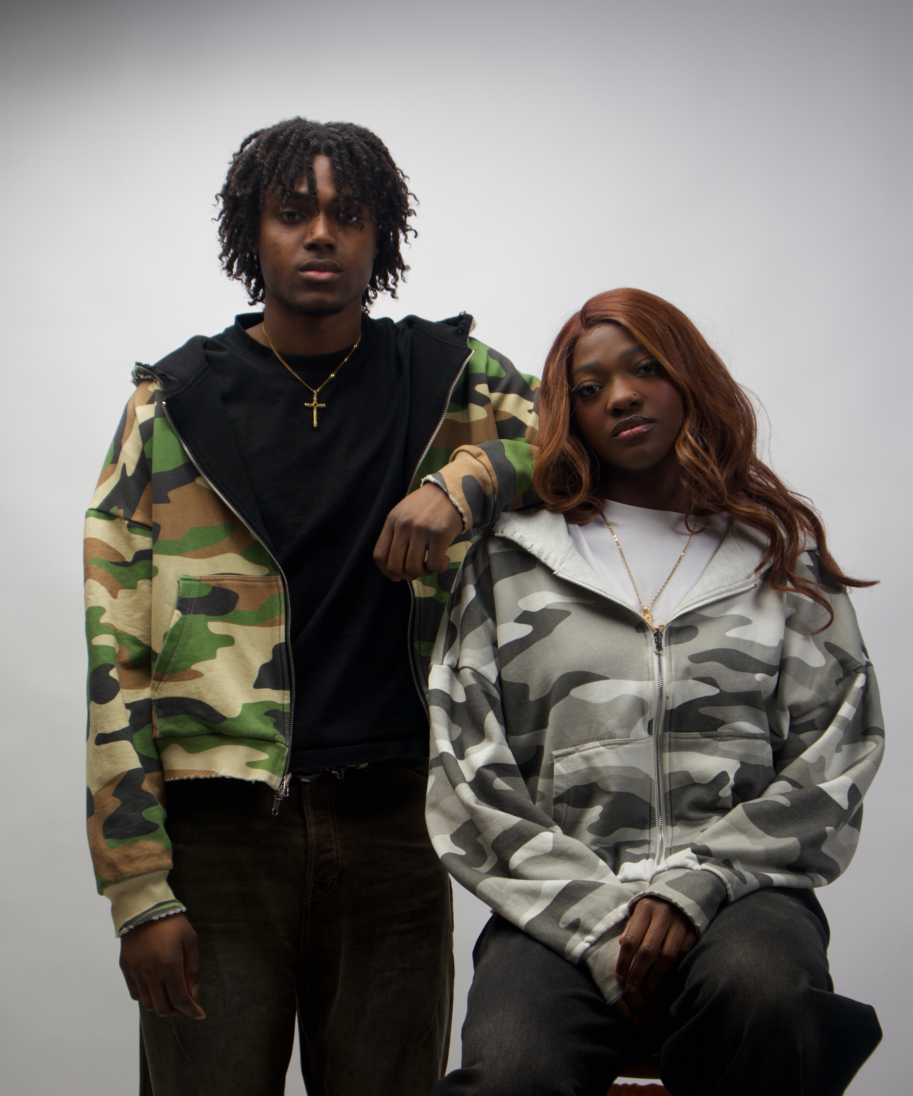 Two models in the olive and snow camo hoodies